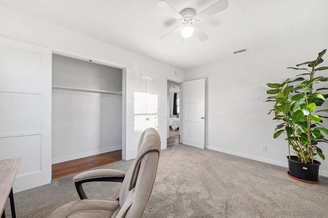 carpeted office space featuring ceiling fan