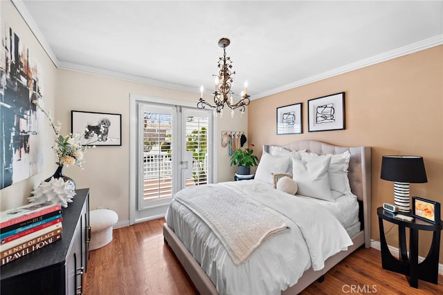 bedroom featuring dark hardwood / wood-style flooring, access to exterior, ornamental molding, and a chandelier