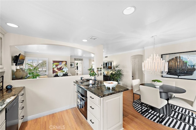 kitchen featuring light hardwood / wood-style flooring, black appliances, dark stone counters, and white cabinets