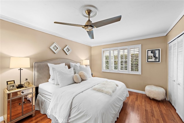 bedroom featuring crown molding, ceiling fan, dark hardwood / wood-style flooring, and a closet