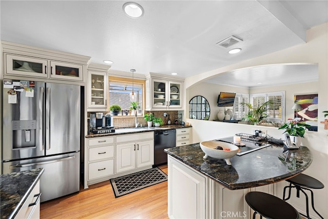 kitchen with sink, a breakfast bar, black dishwasher, stainless steel refrigerator with ice dispenser, and decorative light fixtures