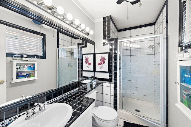 bathroom featuring a shower with door, vanity, ceiling fan, and toilet