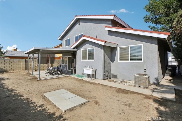 back of house with central AC unit and a patio