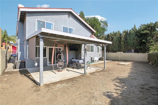 back of property with cooling unit and a patio