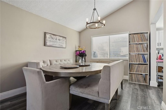 dining space featuring lofted ceiling, dark hardwood / wood-style flooring, a chandelier, and a textured ceiling