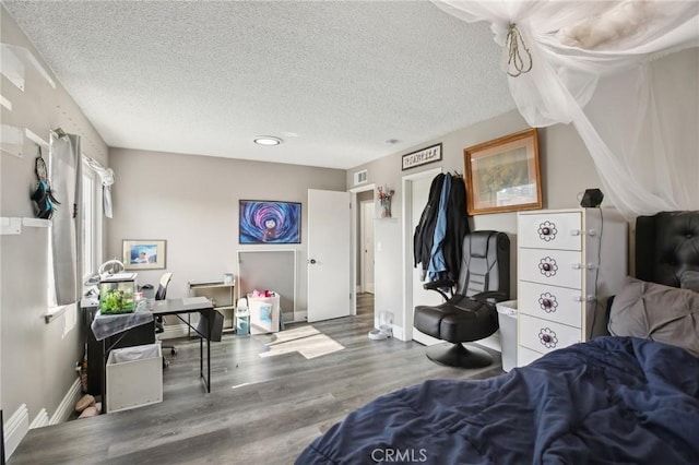 bedroom with wood-type flooring and a textured ceiling