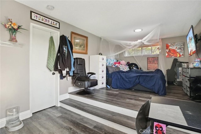 bedroom with dark hardwood / wood-style floors