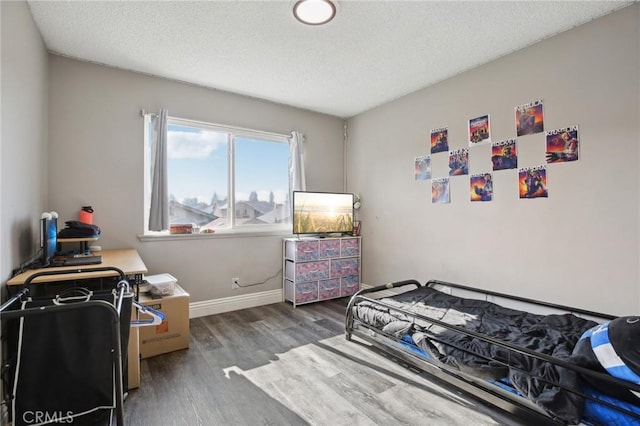 bedroom with dark hardwood / wood-style floors and a textured ceiling