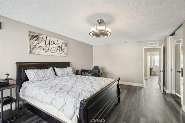 bedroom with dark hardwood / wood-style floors and a textured ceiling