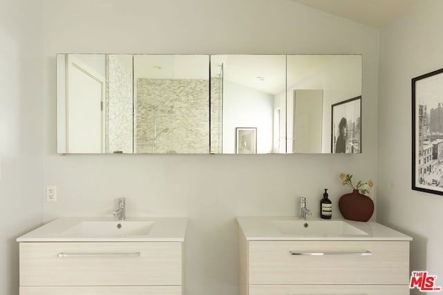 bathroom with vanity, lofted ceiling, and a shower