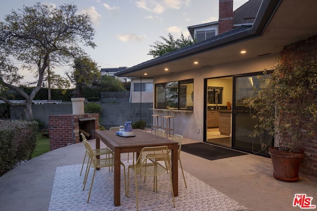 patio terrace at dusk featuring a bar