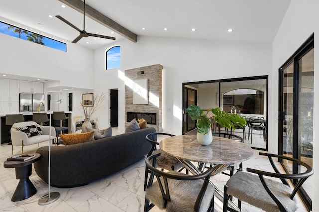 living room featuring beamed ceiling, ceiling fan, and high vaulted ceiling