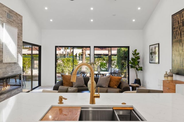 kitchen with plenty of natural light, light stone countertops, and high vaulted ceiling