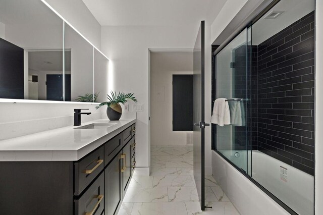 bathroom featuring vanity and bath / shower combo with glass door