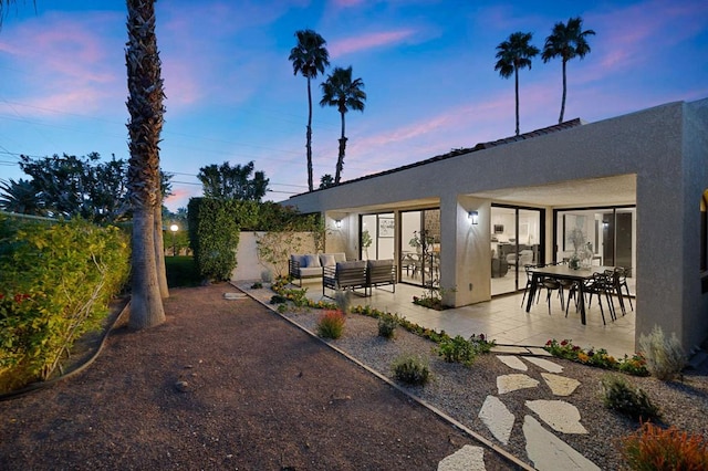 back house at dusk with an outdoor hangout area and a patio area