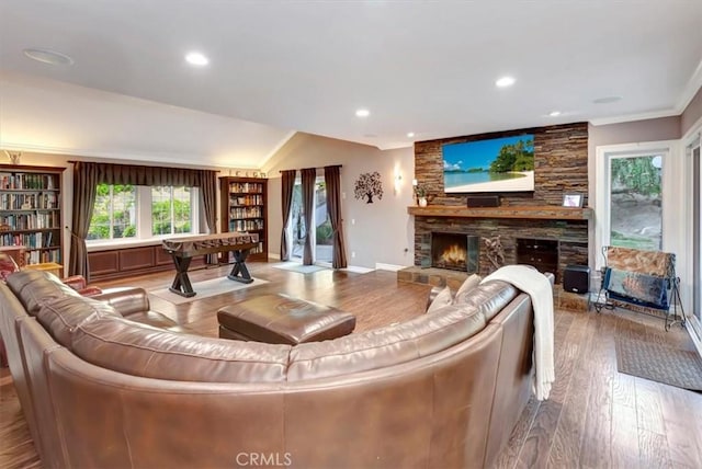 living room with crown molding, a fireplace, and light wood-type flooring