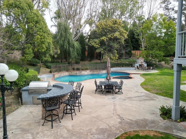 view of pool with exterior kitchen, a patio, exterior bar, and grilling area