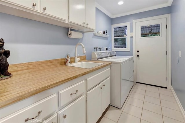 laundry room featuring sink, cabinets, ornamental molding, light tile patterned floors, and washer and clothes dryer