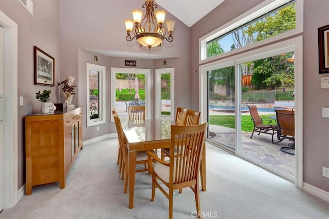 dining space with lofted ceiling, a chandelier, and light carpet