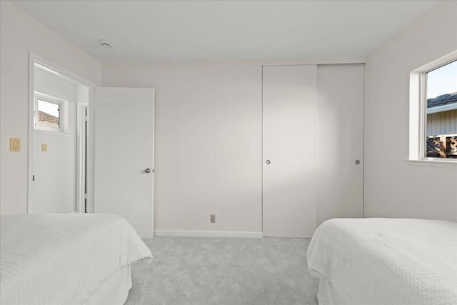 bedroom featuring light carpet and a closet