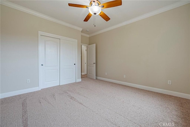 unfurnished bedroom with ceiling fan, ornamental molding, carpet flooring, and a closet