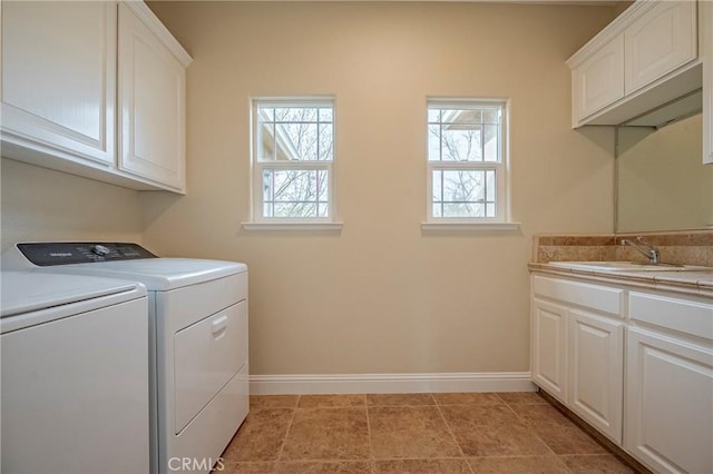 clothes washing area featuring cabinets, separate washer and dryer, sink, and plenty of natural light