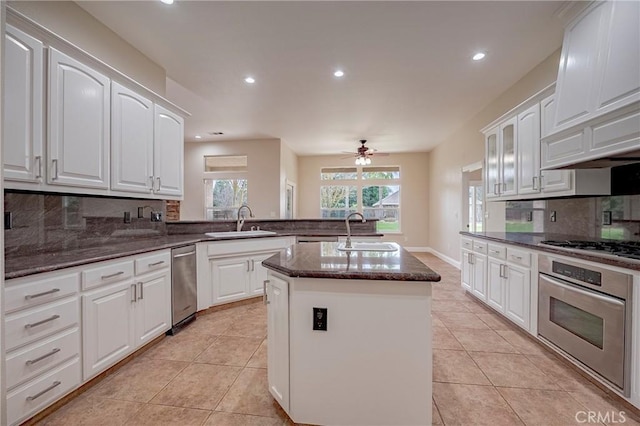 kitchen featuring white cabinetry, an island with sink, appliances with stainless steel finishes, and sink