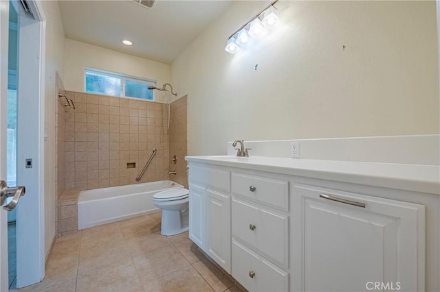 full bathroom with tile patterned flooring, vanity, tiled shower / bath, and toilet