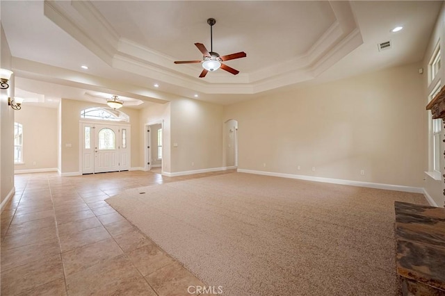 unfurnished living room featuring crown molding, ceiling fan, a tray ceiling, and light tile patterned flooring