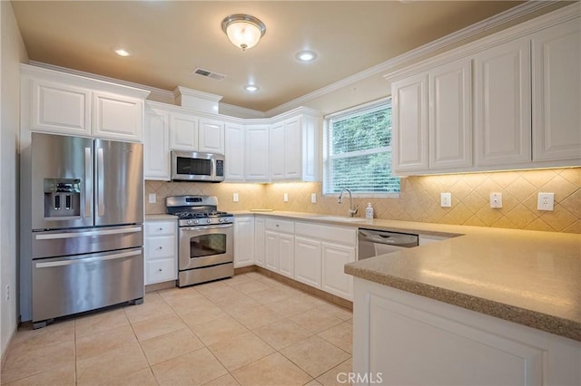 kitchen featuring sink, light tile patterned floors, white cabinetry, backsplash, and stainless steel appliances