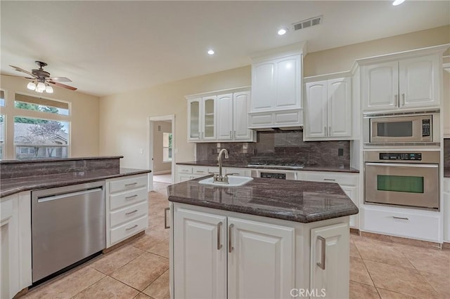 kitchen with a kitchen island with sink, sink, white cabinetry, and stainless steel appliances