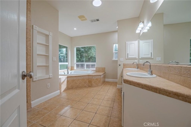 bathroom with a relaxing tiled tub, tile patterned floors, built in features, and vanity