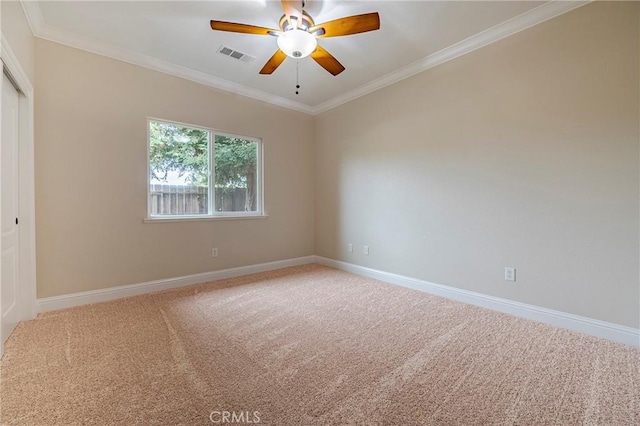 empty room featuring ornamental molding, carpet, and ceiling fan