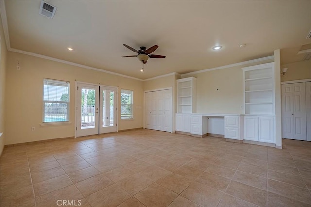 unfurnished living room with light tile patterned flooring, french doors, crown molding, built in desk, and ceiling fan