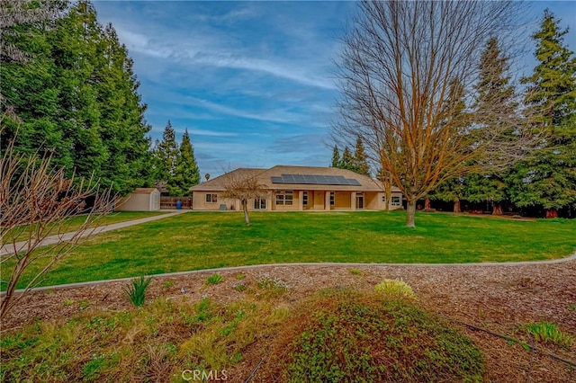 view of front of home featuring a front yard and solar panels