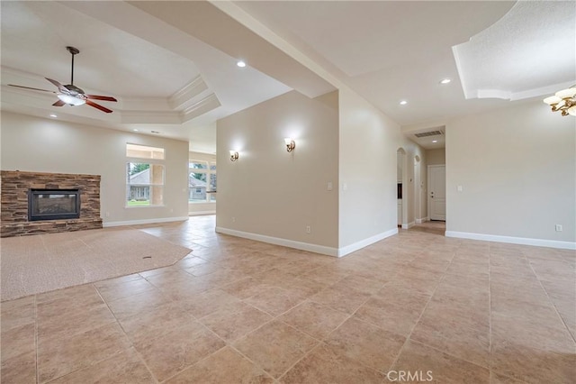 unfurnished living room with a raised ceiling, ceiling fan, light tile patterned floors, and a fireplace