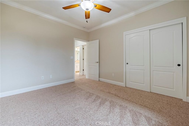 unfurnished bedroom featuring crown molding, carpet floors, a closet, and ceiling fan