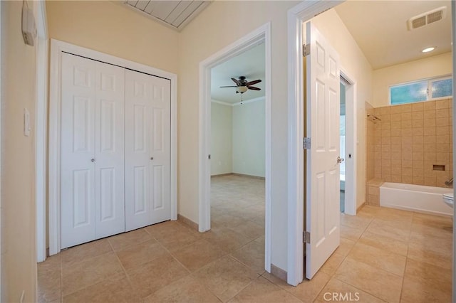 hall featuring ornamental molding and light tile patterned floors