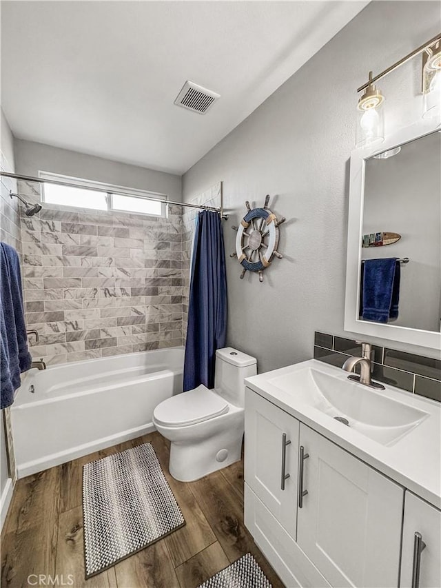 full bathroom with wood-type flooring, toilet, shower / tub combo with curtain, and vanity