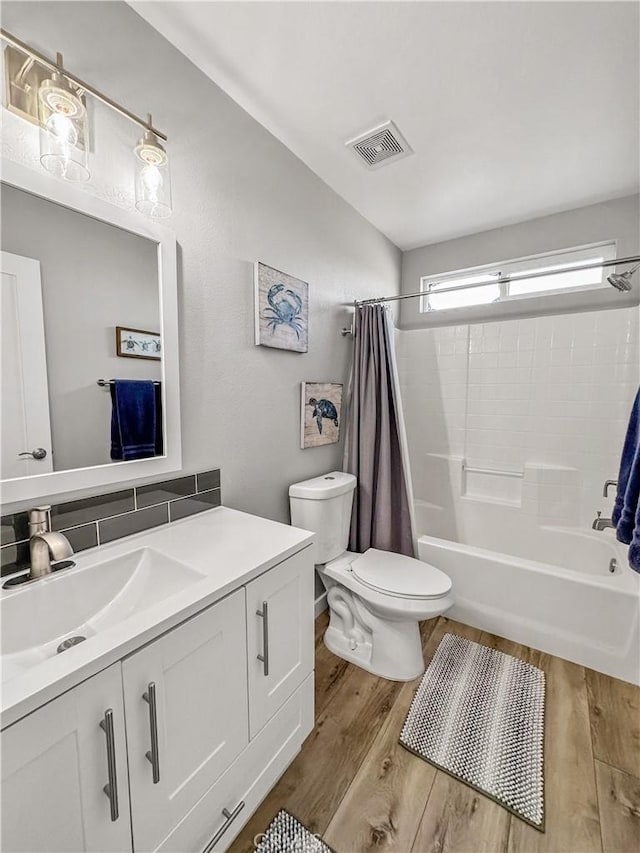 full bathroom featuring vanity, hardwood / wood-style floors, toilet, and shower / bath combo