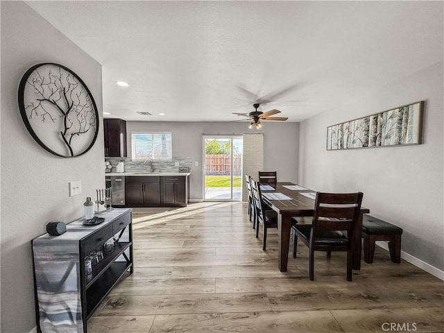 dining area with ceiling fan, sink, and light hardwood / wood-style floors