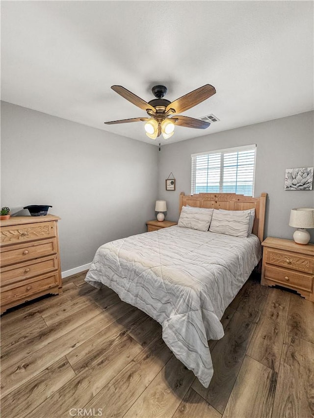 bedroom with wood-type flooring and ceiling fan