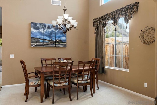 carpeted dining room featuring a chandelier