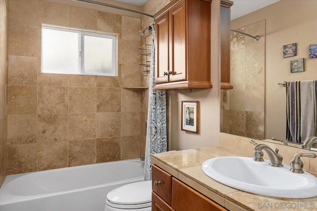 full bathroom with vanity, tiled shower / bath combo, and toilet