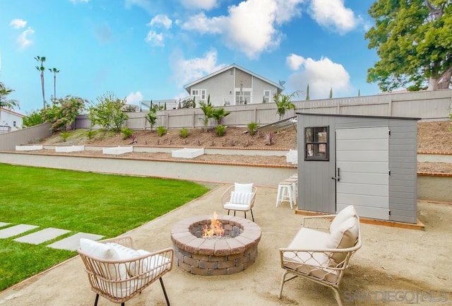 view of yard with a patio, a storage unit, and an outdoor fire pit