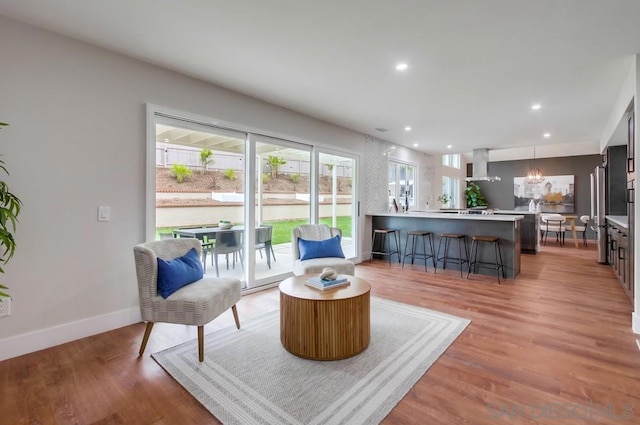 living room featuring a chandelier and light hardwood / wood-style flooring