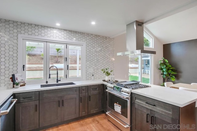 kitchen with sink, extractor fan, appliances with stainless steel finishes, kitchen peninsula, and light hardwood / wood-style floors