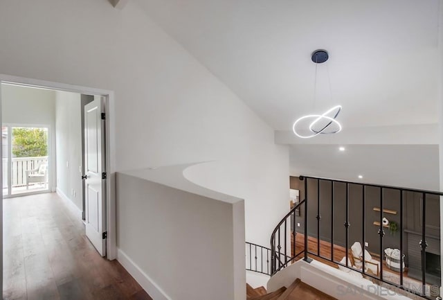 hallway featuring an inviting chandelier, high vaulted ceiling, and hardwood / wood-style floors