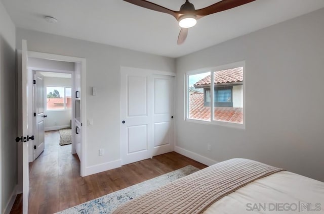 bedroom with wood-type flooring, ceiling fan, and a closet