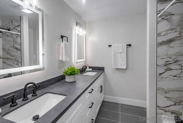 bathroom with tile patterned floors, vanity, and a tile shower